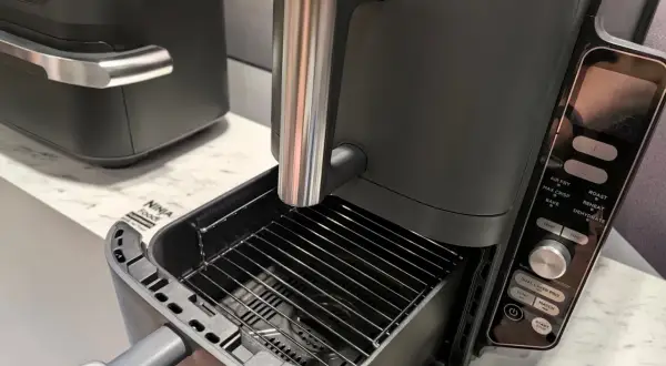 Nowoczesny czarny multicooker Ninja Foodi z wysuwanym rusztem. Ninja co to za firma? To producent innowacyjnych urządzeń kuchennych.