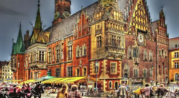 Das **Rathaus Breslau** mit seinen Türmchen und Verzierungen, ein Pferdewagen und Menschen auf dem Platz.