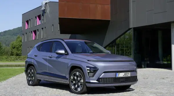 Le plus petit SUV, un véhicule gris moderne, se gare devant un bâtiment architectural audacieux.