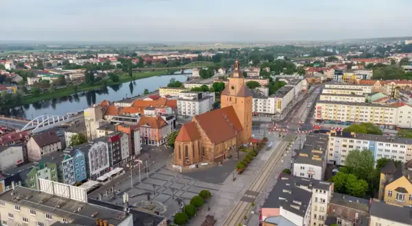 Gorzów Wielkopolski atrakcje dla dzieci: malowniczy widok na miasto z rzeką, kościołem i kolorowymi kamienicami. Idealne miejsce na rodzinne wycieczki.