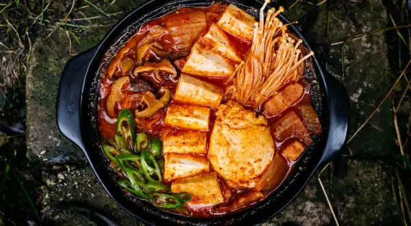 Pikantne kimchi jjigae z tofu, grzybami i zieloną papryczką. Idealny przepis na rozgrzewający posiłek.