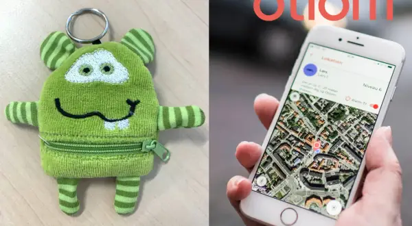 Grüner Monster-Schlüsselanhänger und Smartphone mit Otiom-App. Ein GPS-Tracker für Demenzkranke, der von der Krankenkasse unterstützt wird, gibt Sicherheit.