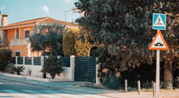 Panneau de passage piétons et ralentisseur. La question "un particulier peut-il filmer la voie publique" se pose devant cette maison.