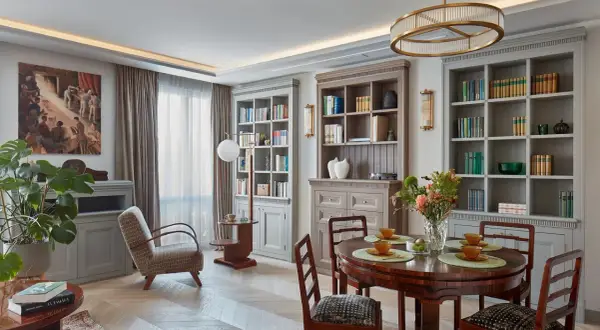 Elegancki salon z biblioteczkami, jadalnią i wygodnym fotelem. Klasyczny styl dekoracji wnętrz.