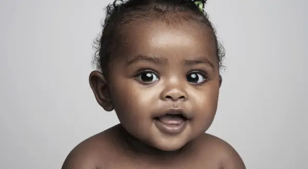 Un bébé aux grands yeux s'exclame, son prénom en X, peut-être Xena ou Xavier, plein de curiosité.