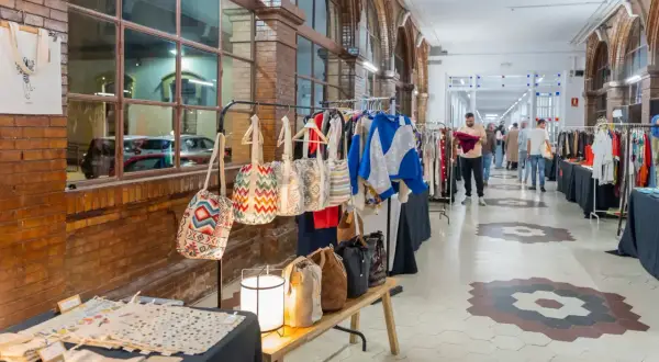 Mercado de artesanía con bolsos coloridos y ropa, evocando las tradiciones de Málaga.