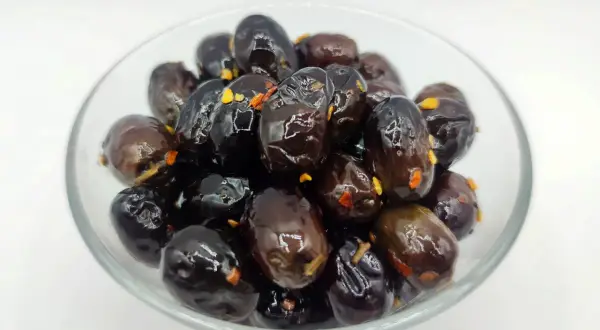 Olive nere sotto sale, un classico della ricetta marchigiana, in una ciotola di vetro.