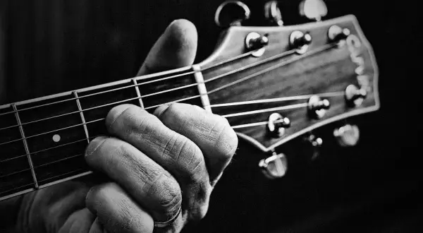 Dłoń z pierścionkiem na serdecznym palcu chwyta akord na gryfie gitary. Powstają piękne utwory na gitarę.