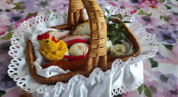 Kiedy się świeci koszyczek, widać w nim jajka, kiełbasę, chleb i żółtego kurczaczka.