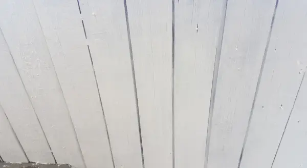 Vitmålad träpanel som takfot, redo för ett nytt lager färg.