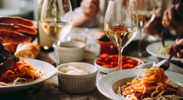 En härlig middag med spaghetti och tomatsås, perfekt som middagstips vardag. Glas med vitt vin och bröd kompletterar måltiden.