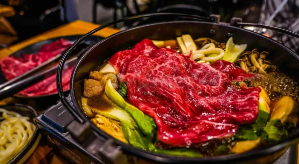 Ein dampfender Hot Pot Japan mit zartem Rindfleisch, Pilzen und Gemüse.