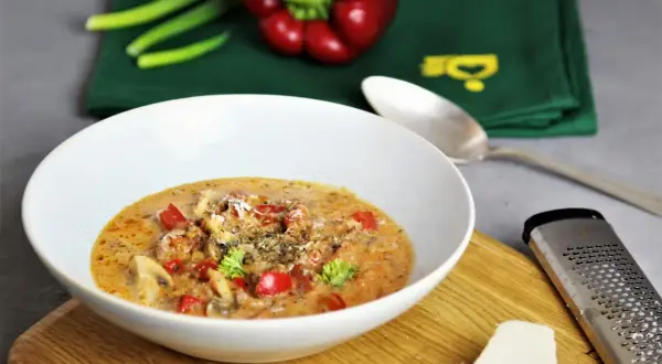 Herzhaftes Pizzasuppe Rezept: cremige Suppe mit Paprika, Pilzen und Käse, garniert mit Petersilie. Perfekt für kalte Tage!