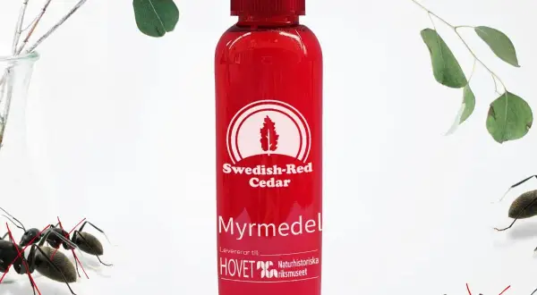 Röd flaska med "Myrmedel" och "Swedish-Red Cedar" text. Myror i rabatten, men denna produkt hjälper mot dem.