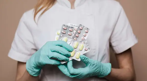 Lekarz w rękawiczkach trzyma opakowania leków, które mogą być skutecznym lekiem na neuralgię nerwu trójdzielnego.