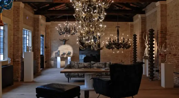 Interno con lampadari di cristallo e arredi moderni. Un'opera di Fabio Fornasier illumina l'ambiente.
