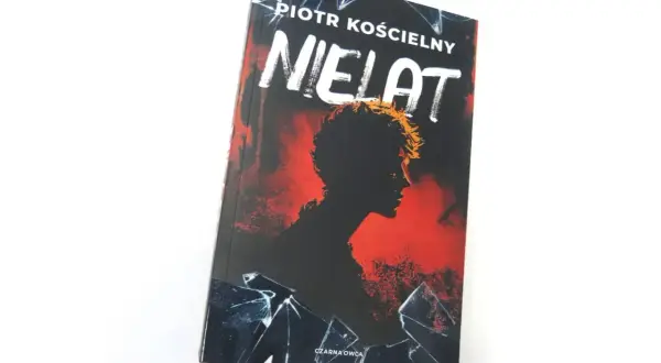 Okładka książki "Nielat" Piotra Kościelnego. Mroczna sylwetka postaci na tle czerwieni i pękniętego szkła.