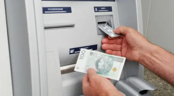Wpłatomat przyjmuje banknoty, w tym 100 zł. Widać też wkładanie karty.