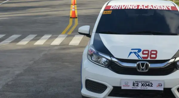 Samochód z napisem "Driving Academy" na placu manewrowym. Może to być miejsce, gdzie można zdobyć prawo jazdy od 16 lat.