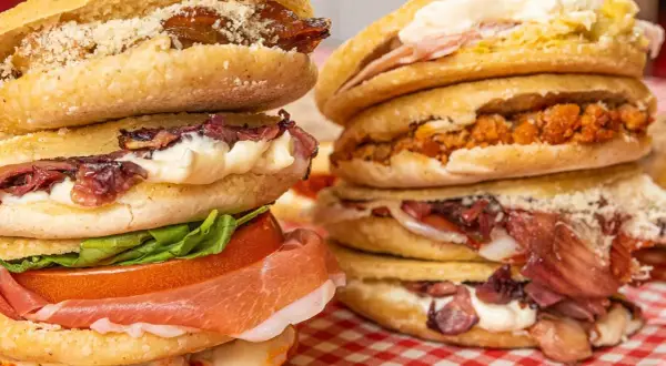 Ecco cosa sono le tigelle: dischi di pane morbido farciti con salumi, formaggio, verdure e salse, un vero piacere per il palato.
