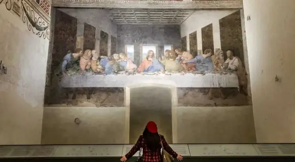 La donna ammira il cenacolo di Leonardo, un'opera d'arte che cattura l'intensità del momento.