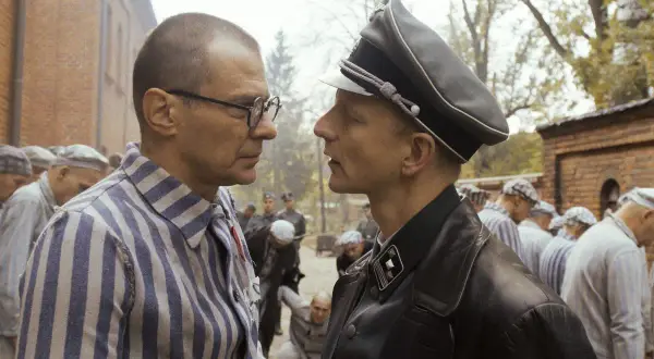 Scena z filmu o Maksymilianie Kolbe: więzień w pasiastej koszuli i oficer SS patrzą sobie w oczy.