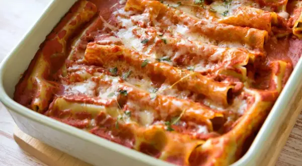 Pyszne cannelloni ze szpinakiem, zapieczone pod sosem pomidorowym i ciągnącym się serem. Idealne na rodzinny obiad.
