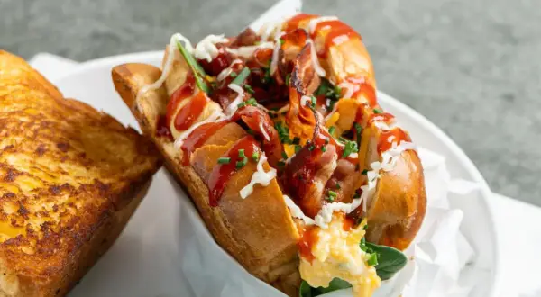Herzhaftes Eggdrop Sandwich mit knusprigem Speck, Rührei, Käse und Ketchup, serviert mit geröstetem Käse-Toast.