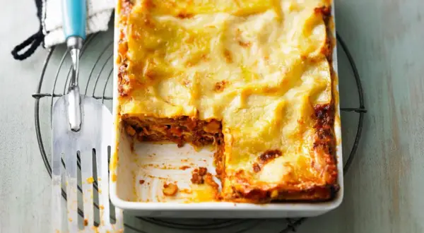 Herzhaftes Lasagne Rezept mit goldbrauner Käsekruste, bereit zum Servieren. Ein Stück wurde bereits entnommen.