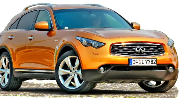 Pomarańczowy infiniti samochód z chromowanymi detalami i felgami.