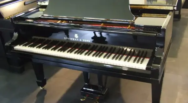 Błyszczący fortepian Steinway & Sons, jeden z najbardziej cenionych **marek fortepianów**, gotowy do wykonania pięknej melodii.