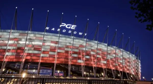 PGE Narodowy nocą, oświetlony w barwach narodowych. Imponująca pojemność stadionu robi wrażenie.