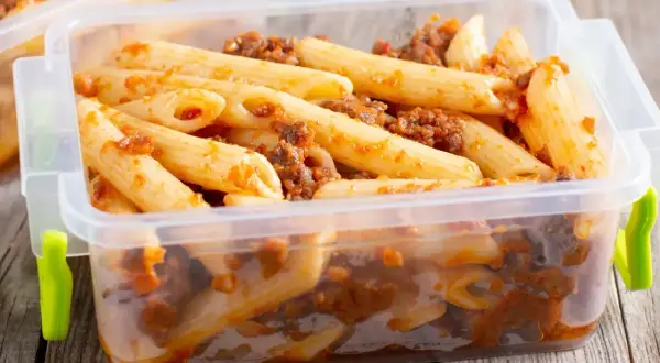 Penne z sosem bolońskim w pojemniku. Czy ugotowany makaron można zamrozić? Tak, to świetny sposób na przechowywanie posiłków.
