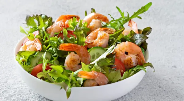 Salade de crevettes fraîche et colorée, garnie de légumes croquants et de tomates juteuses.