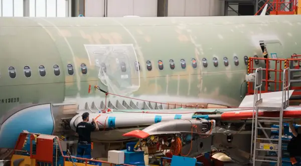 Arbeiter im Airbus-Werk montieren Flugzeugteile. Der Airbus-Tarifvertrag regelt die Arbeitsbedingungen.