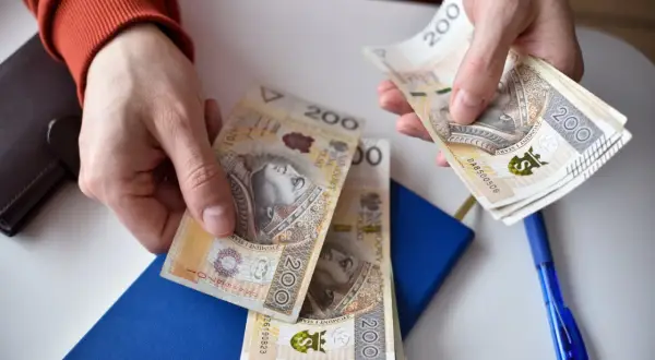 Ręce liczą banknoty 200 zł. Ile godzin nocnych w miesiącu można za nie opłacić?