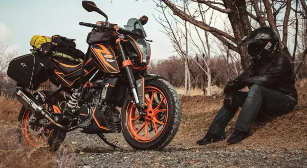 Pomarańczowy motocykl KTM z sakwami, gotowy na przygodę. Idealny sprzęt na pierwsze enduro.