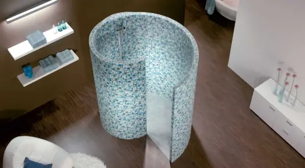 Une douche escargot aux mosaïques bleues et vertes, avec une baignoire et un fauteuil blanc dans une salle de bain moderne.