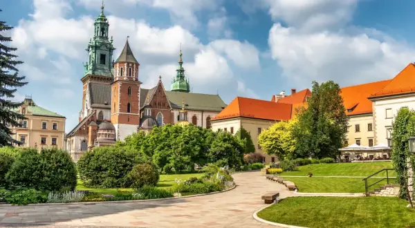 Wawel cennik: malowniczy widok na zamek i katedrę z zielonymi ogrodami i brukowanymi alejkami.