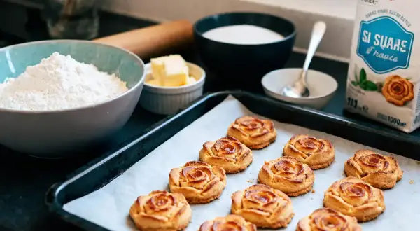 Délicieux biscuits en forme de rose des sables dorés sur une plaque de cuisson, prêts à être dégustés.