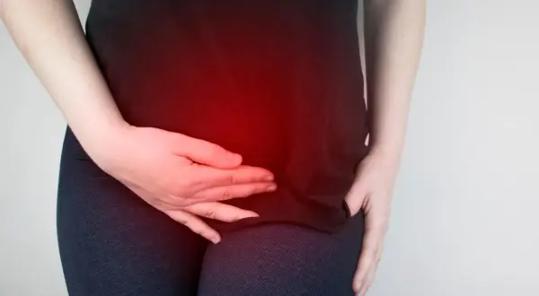 Donna con mani sull'addome, evidenziato da un bagliore rosso, che suggerisce un disagio come la pancia gonfia ovulazione.