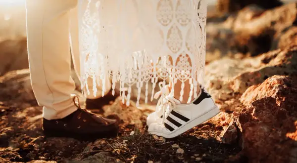 Para test zgodności pytania: para młoda w butach sportowych i eleganckich, na tle skał i zachodzącego słońca.