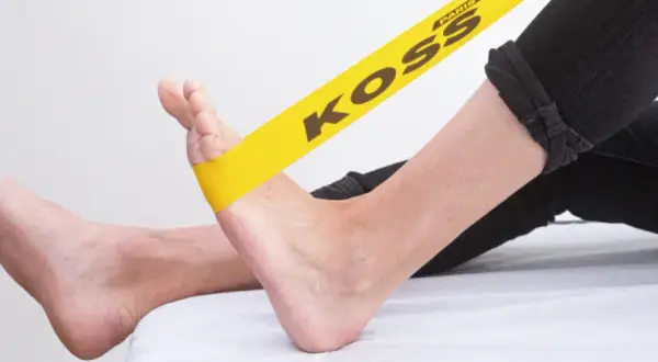 Exercice avec élastique jaune pour soulager la périostite tibiale.