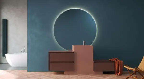 Mobile bagno moderno con lavabo integrato in materiale corian, specchio circolare retroilluminato e finiture in legno.