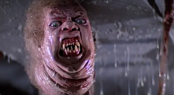 Potwór z klasycznych **filmy sci-fi lata 80.** z przerażającymi zębami i zielonymi oczami, w mokrym, obrzydliwym otoczeniu.
