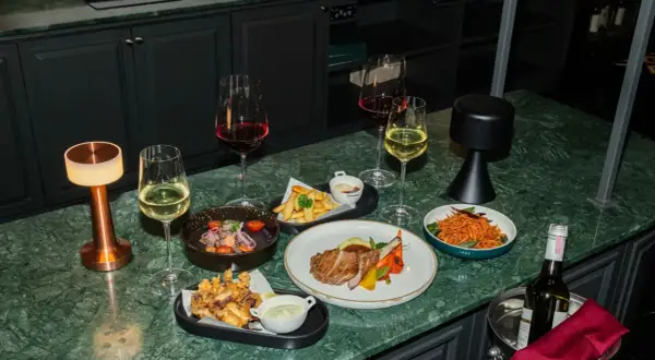 Elegancka kolacja z kieliszkiem chardonnay wino, stekiem, frytkami i sałatką.