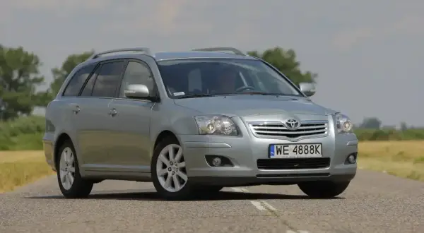 Srebrny kombi Toyota Avensis 1.8 benzyna na drodze.