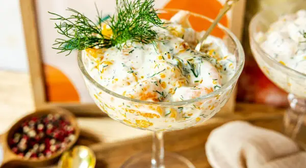 Erfrischender Krabbencocktail mit süßen Mandarinenstücken, cremiger Sauce und Dill garniert.