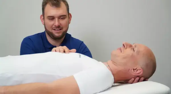 Fizjoterapeuta uspokaja pacjenta, który odczuwa nerwowość i agresję.