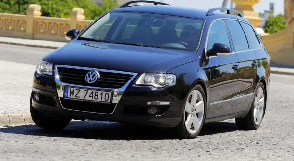 Czarny Passat B6 2.0 TDI 140KM na polskich tablicach WZ 74810, porusza się po brukowanej drodze.